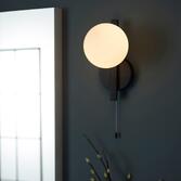 Photograph: Thorlight Java Single Bathroom Wall Light In Matt Black With An Opal Glass Globe - IP44